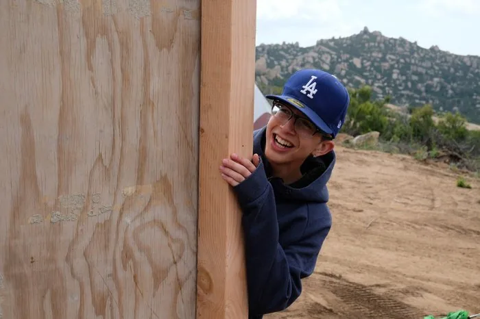 A youth participant laughing and smiling while building the camp structure at Freedom Land